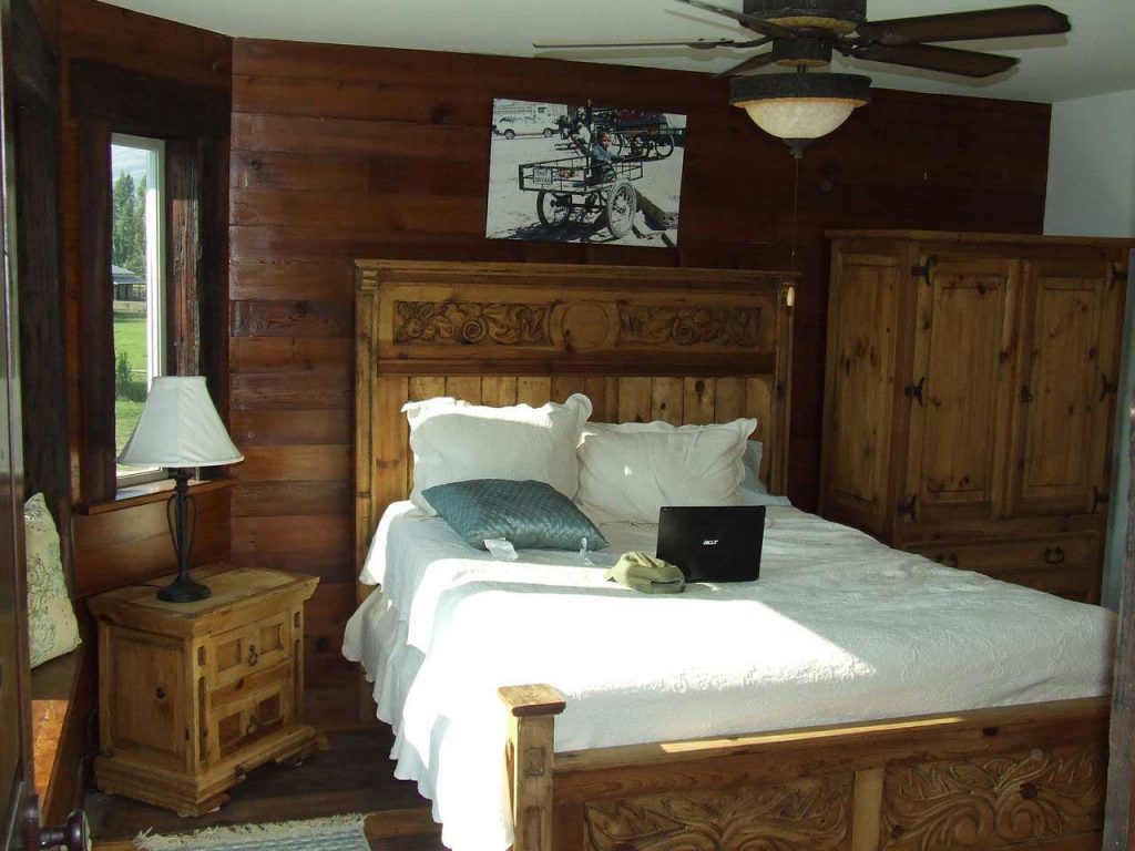 A cozy bedroom with a wooden white bed, complete with a fan and lights for comfort and convenience